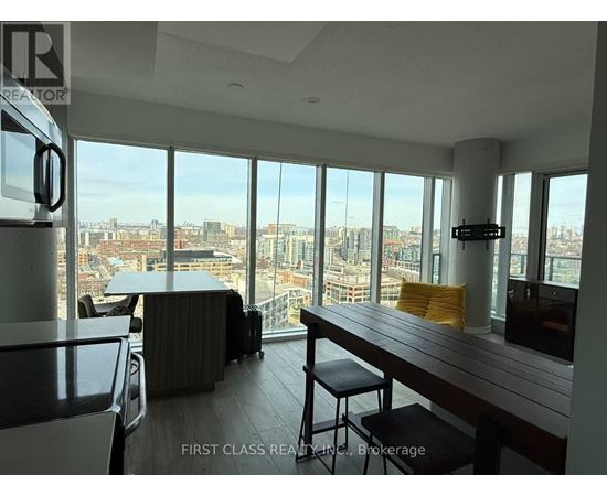 A room with a long table and chairs with a view of the city.