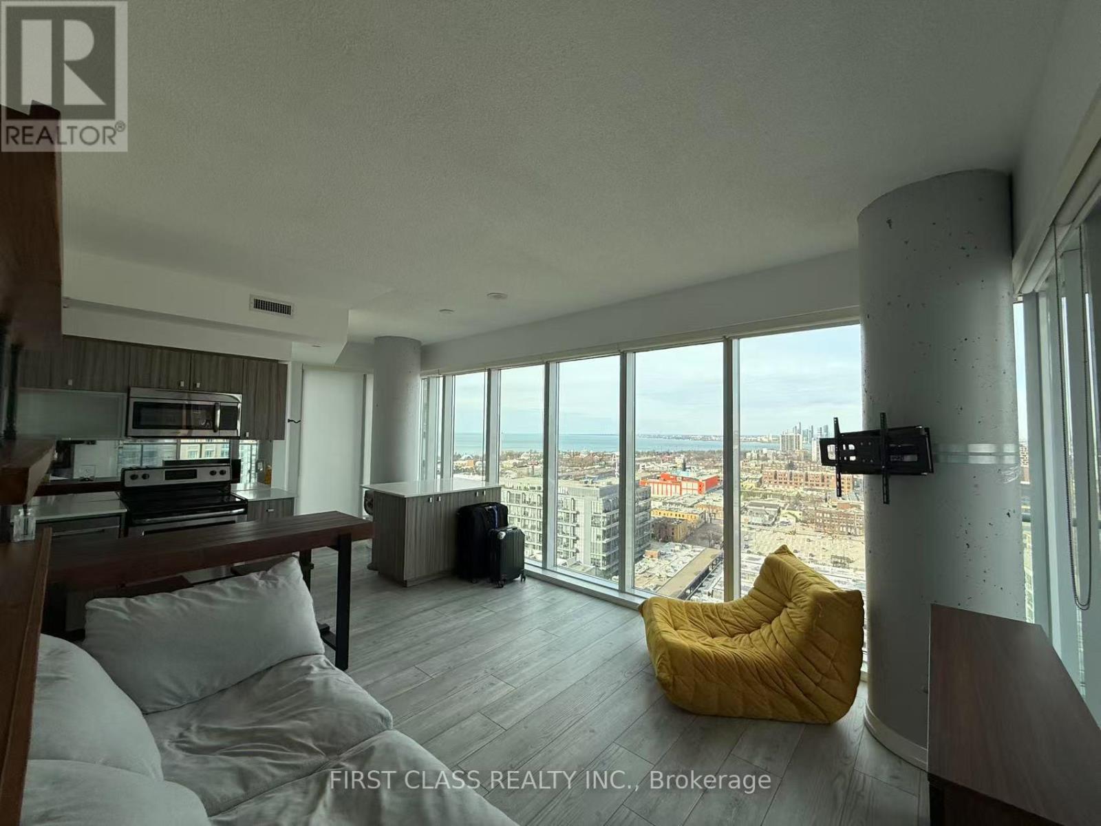 A living room with a large window overlooking a cityscape.