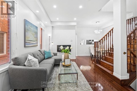 A modern living room with a grey sofa and a glass coffee table.