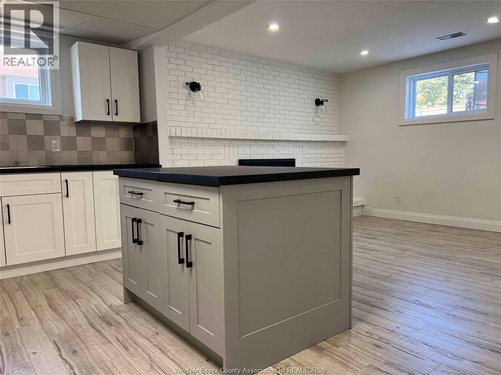 A kitchen with a black countertop and white cabinets.