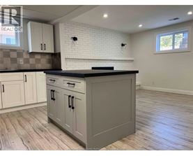 A kitchen with a black countertop and white cabinets.