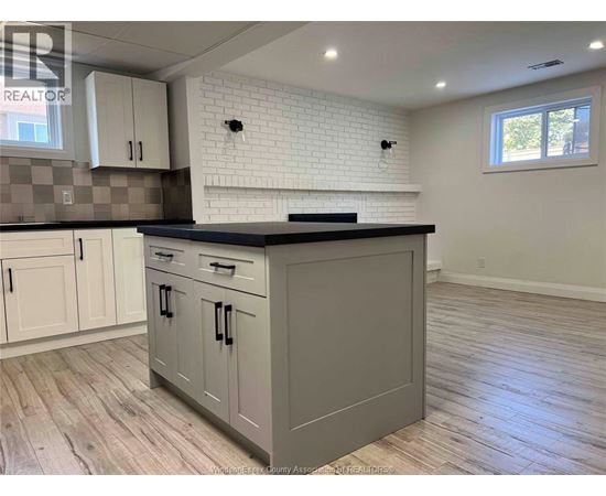 A kitchen with a black countertop and white cabinets.