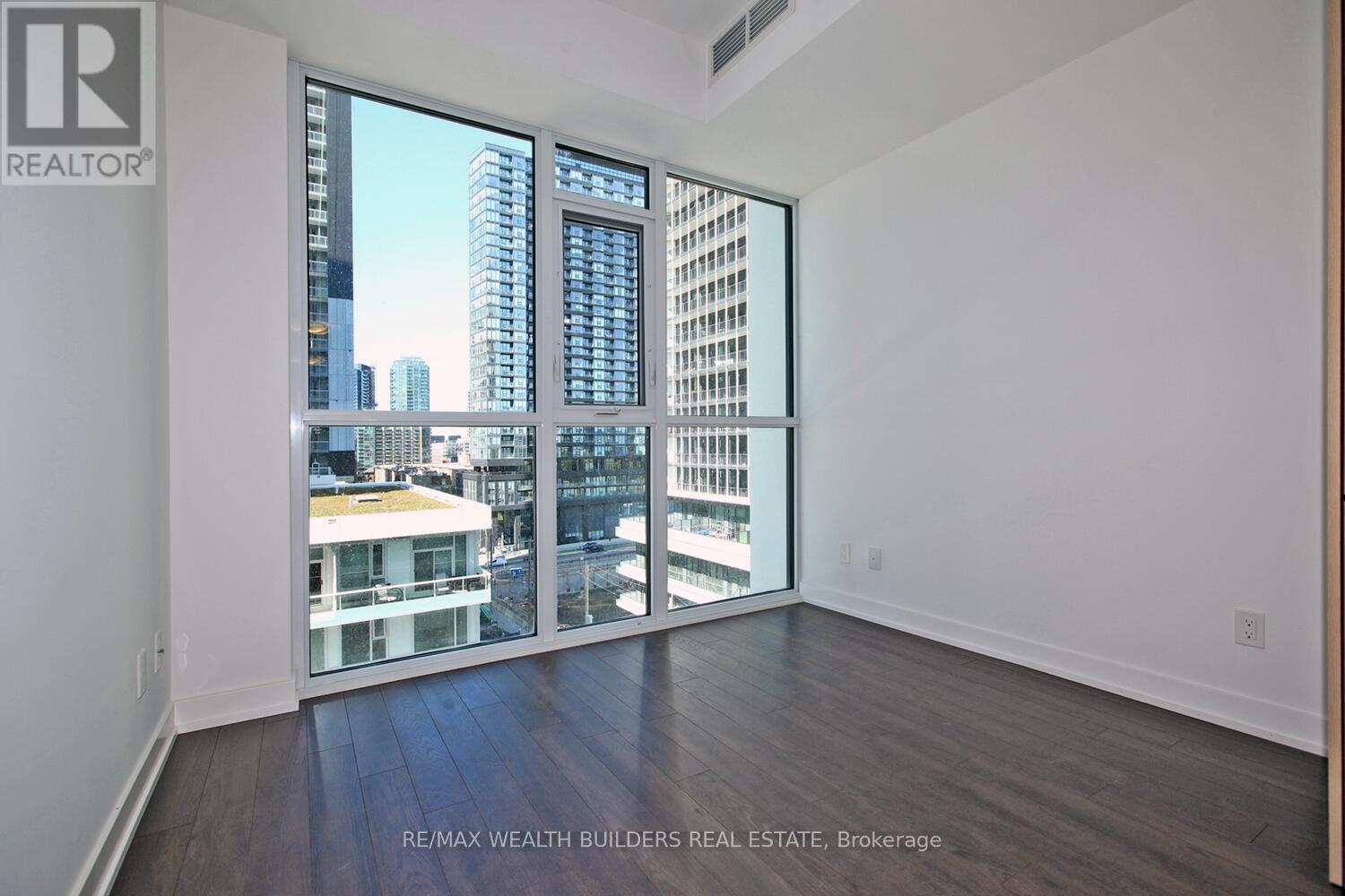A room with a view of the city through large windows.