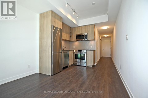 A spacious kitchen with wooden cabinets and stainless steel appliances.