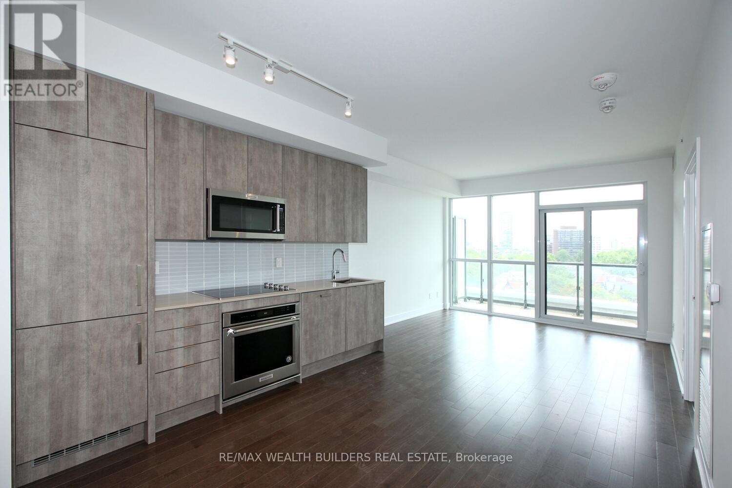A kitchen with a microwave and oven built into a cabinetry wall.