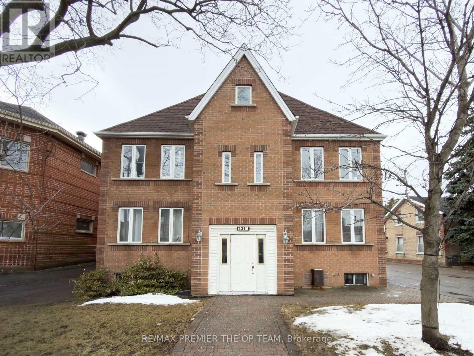 A brick house with a white door and windows.