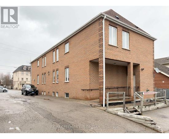 A brick building with a car parked in front.