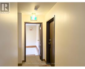 A hallway with a door on the right and another door on the left.