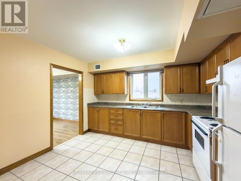 A kitchen with wooden cabinets and a white refrigerator.