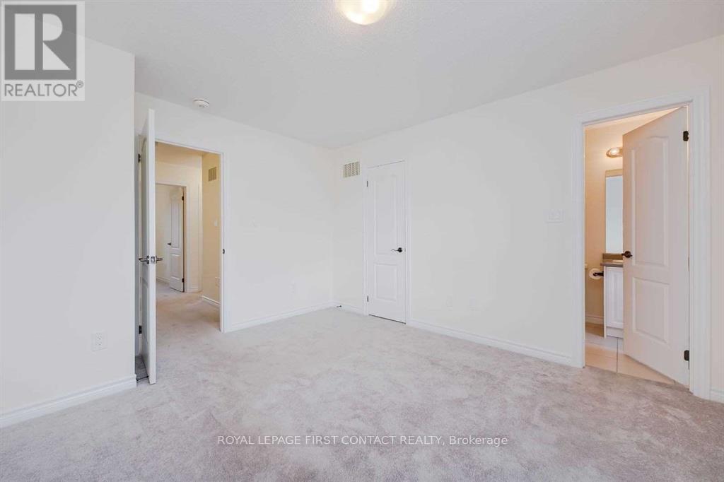 A spacious, empty room with white walls and carpeted floor.