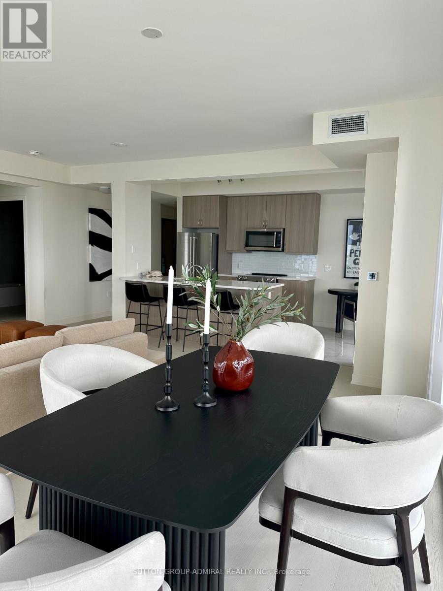 A modern dining room with a black table and white chairs.