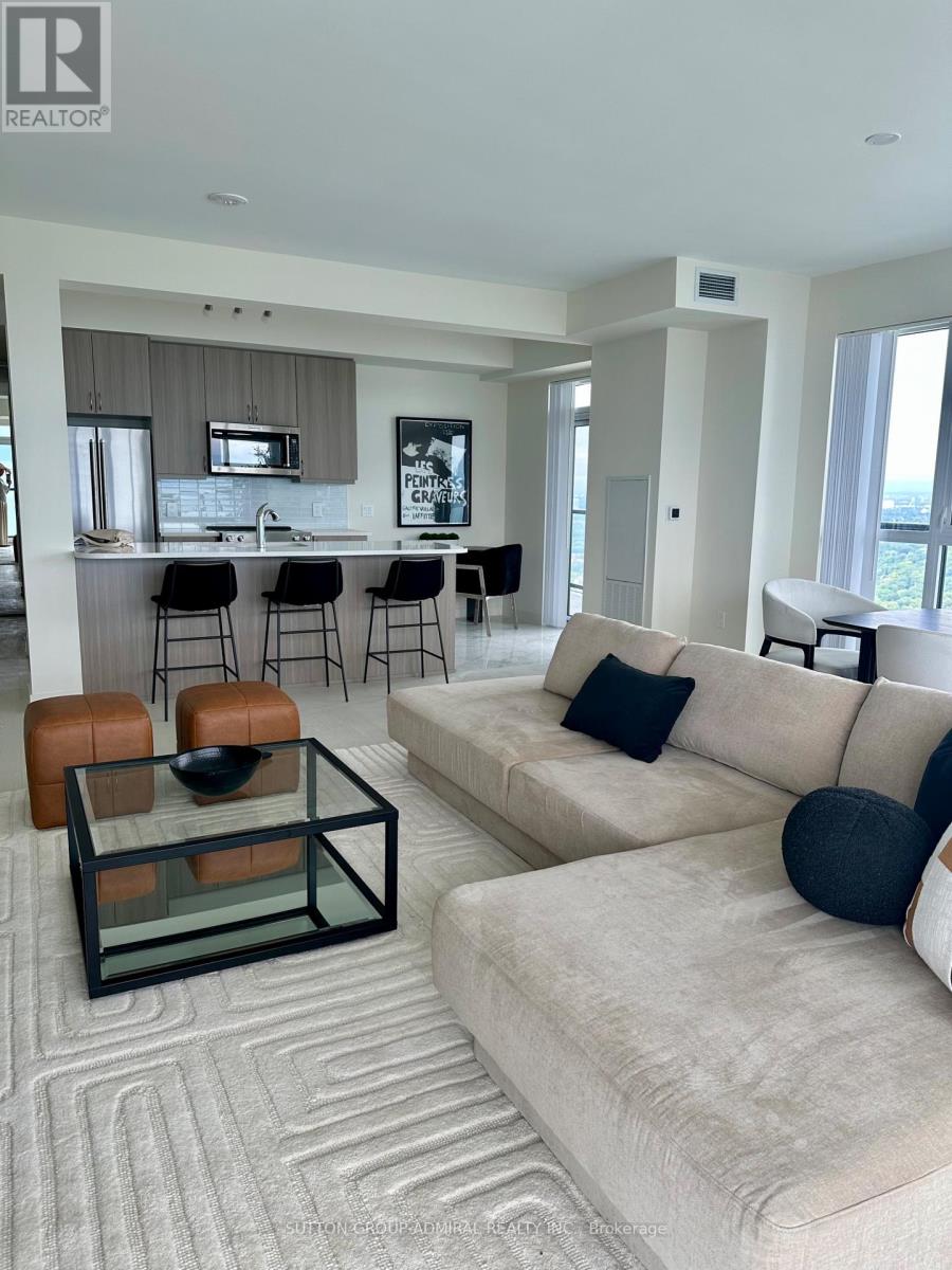 A modern living room with a glass coffee table and a beige sofa.