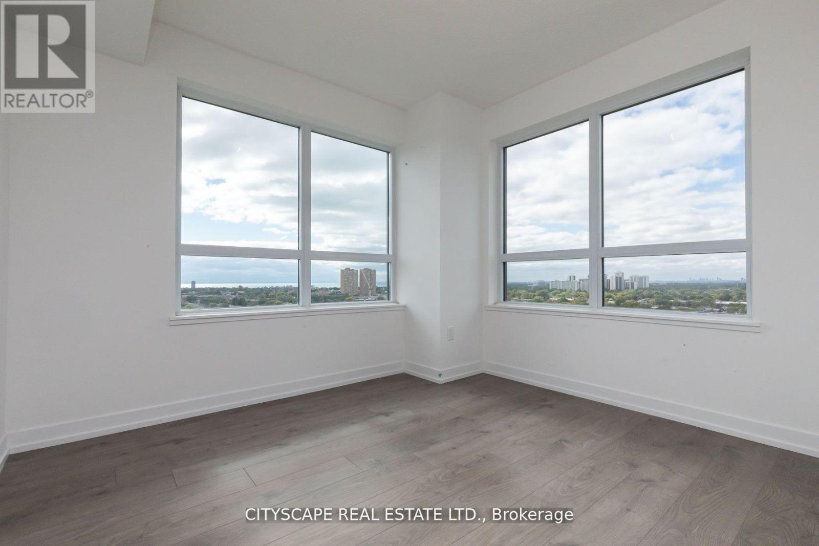 A room with a view of the cityscape through large windows.