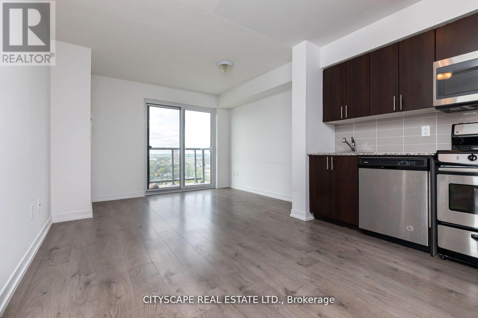 A kitchen with dark wood cabinets and stainless steel appliances.