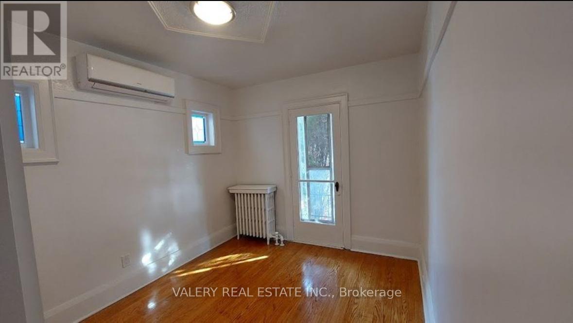 A room with a window, a door, and a radiator.