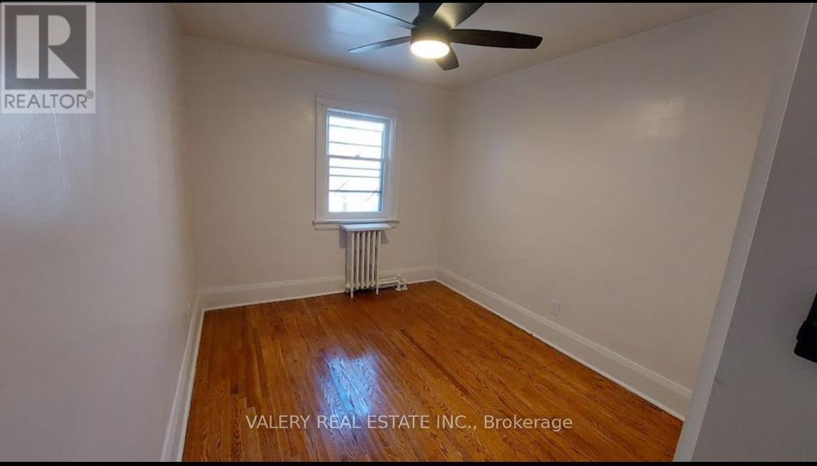 A room with a ceiling fan and a window with blinds.