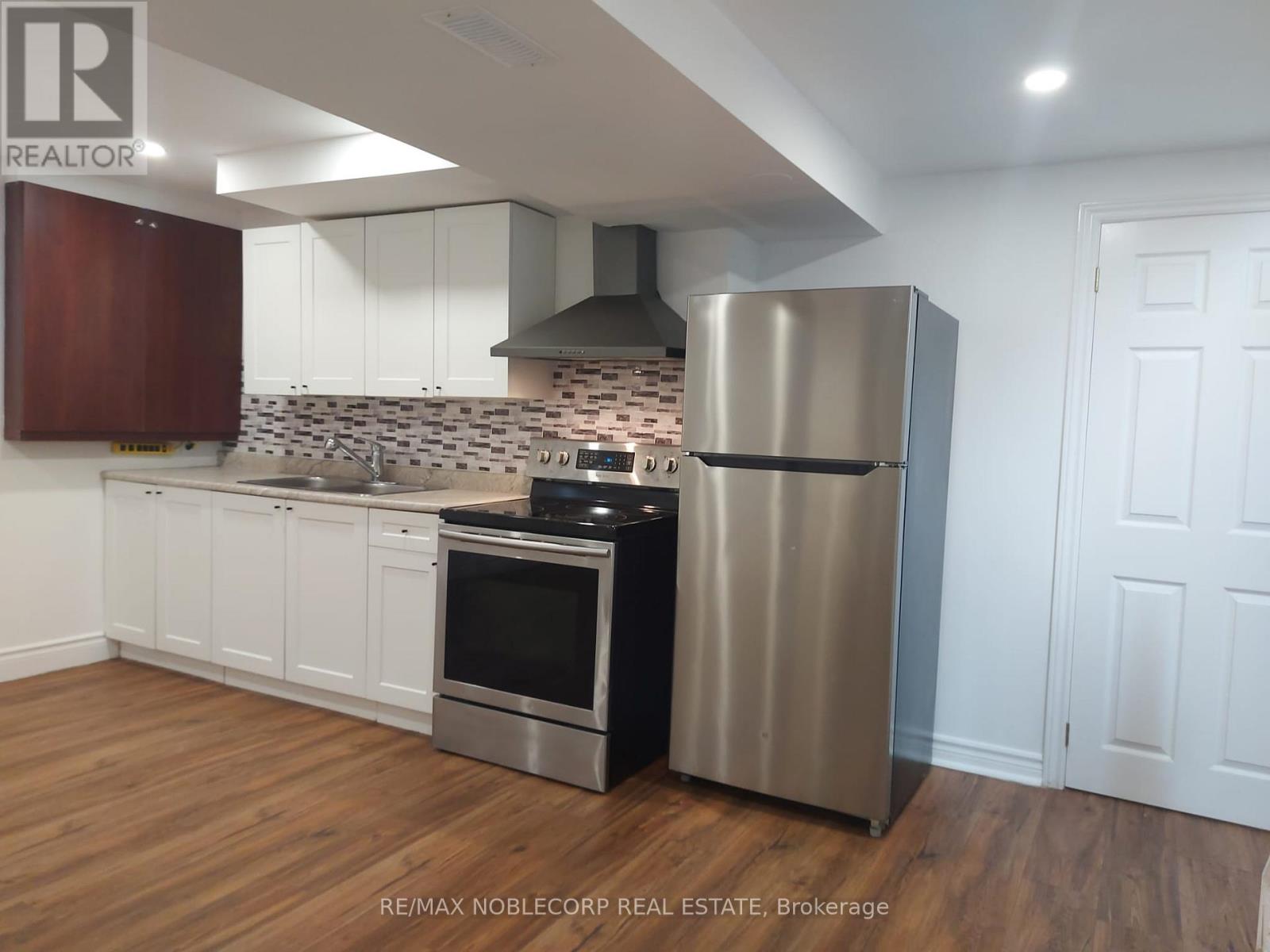 A kitchen with a stainless steel refrigerator and oven.