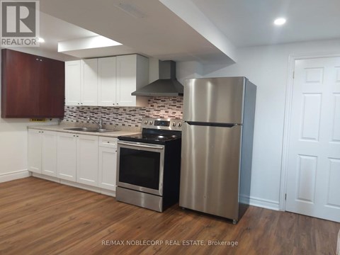A kitchen with a stainless steel refrigerator and oven.