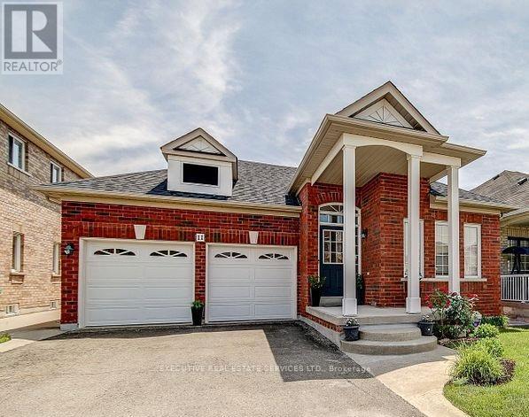 A brick house with a white garage door and a small porch.