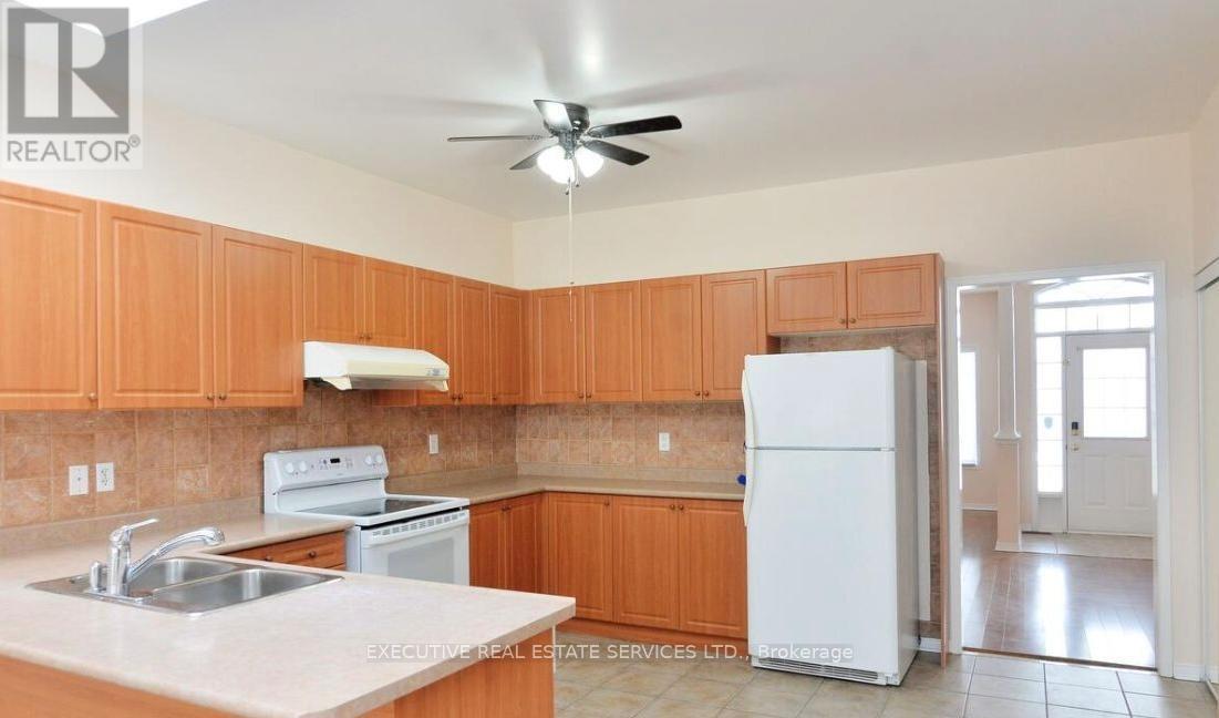 A kitchen with wooden cabinets and a white refrigerator.