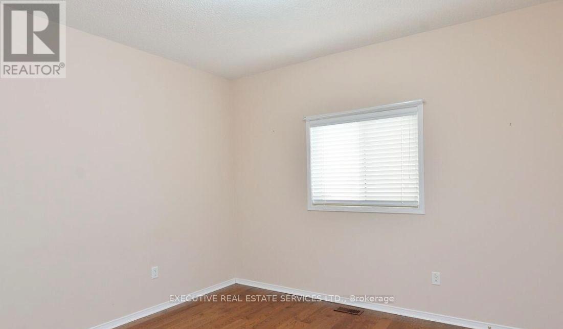 A room with a window and wooden flooring.