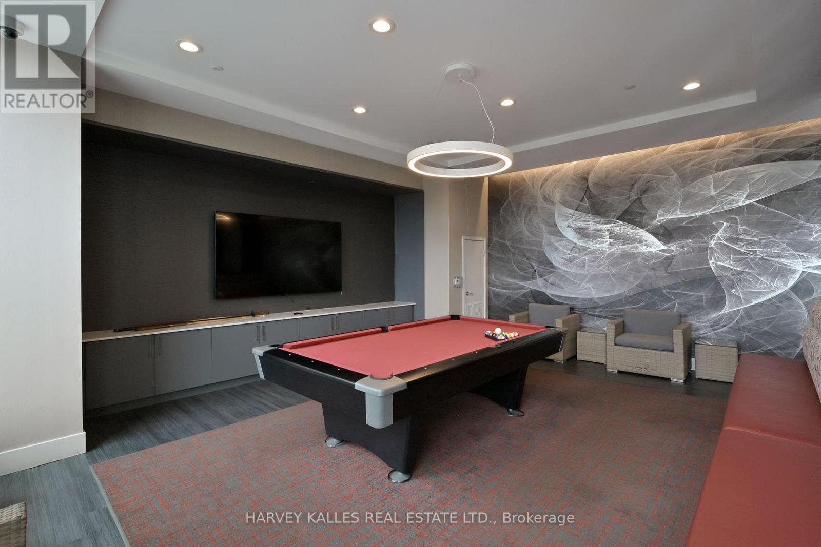 A pool table in a room with a television and a large painting on the wall.