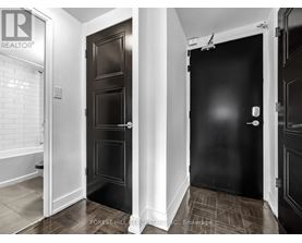 A hallway with two doors and a brokerage sign on the wall.