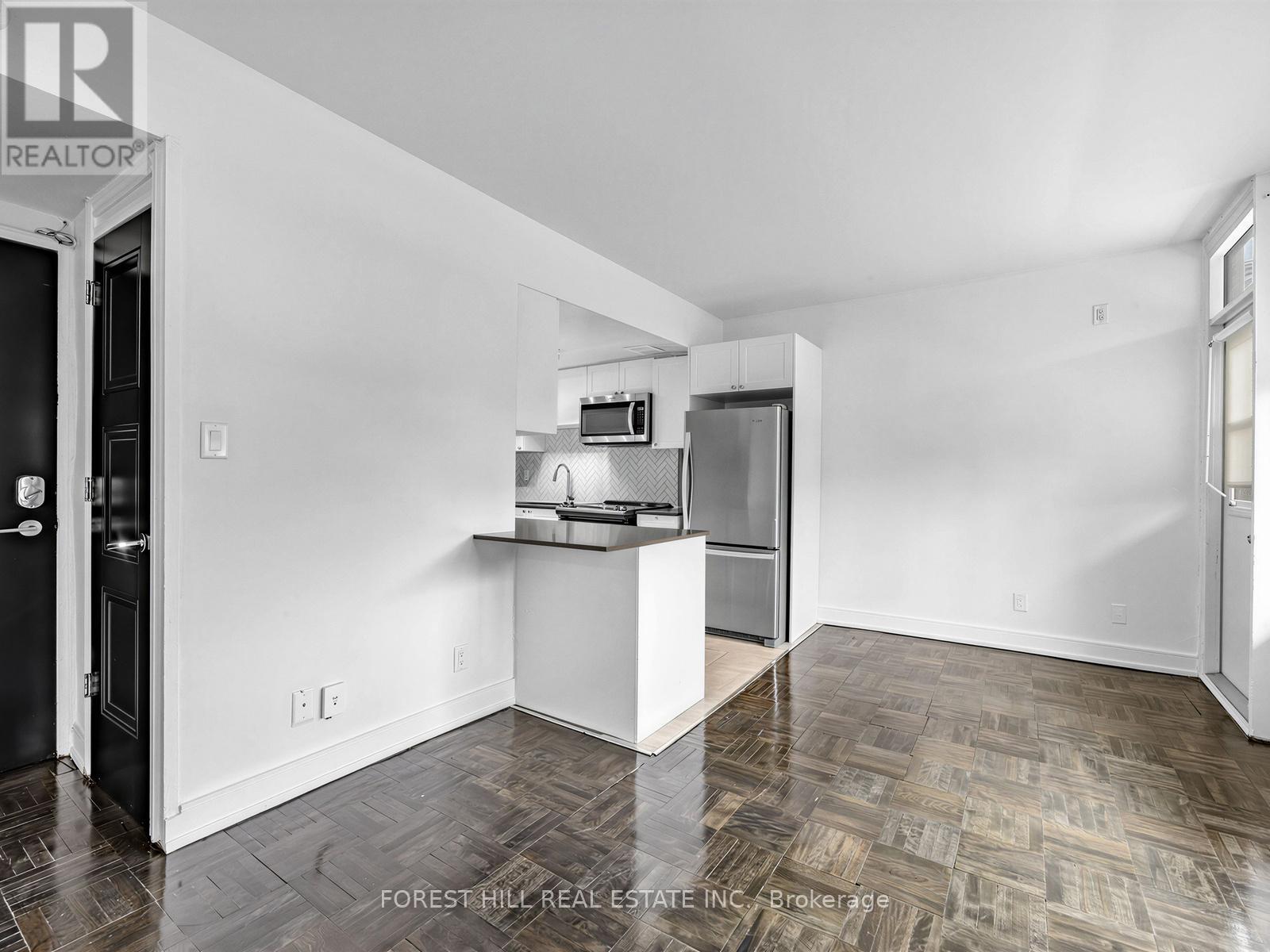 A kitchen area with a refrigerator, microwave, and oven.