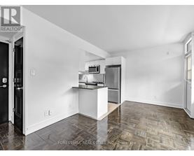 A kitchen area with a refrigerator, microwave, and oven.