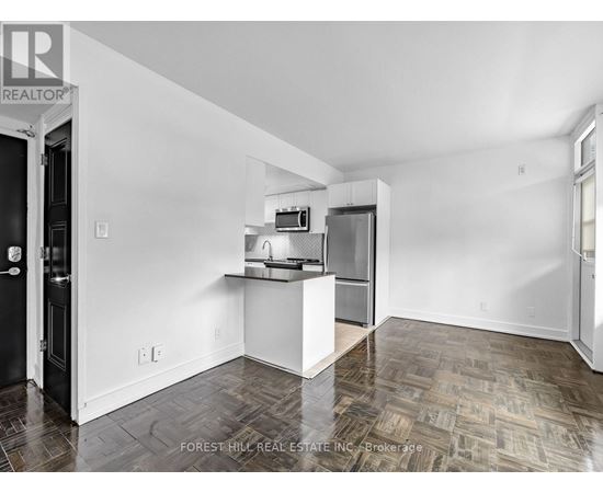 A kitchen area with a refrigerator, microwave, and oven.