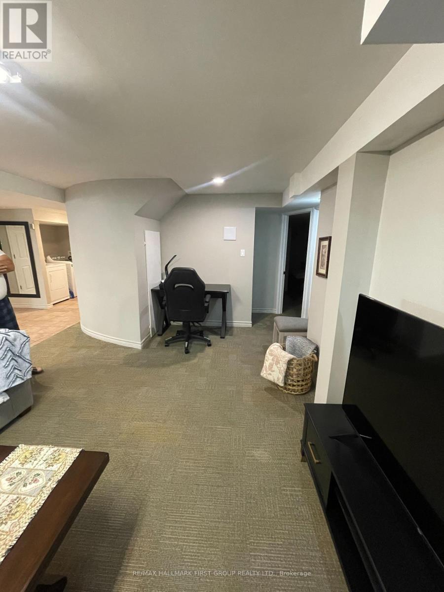 A living room with a couch, a chair, and a television.