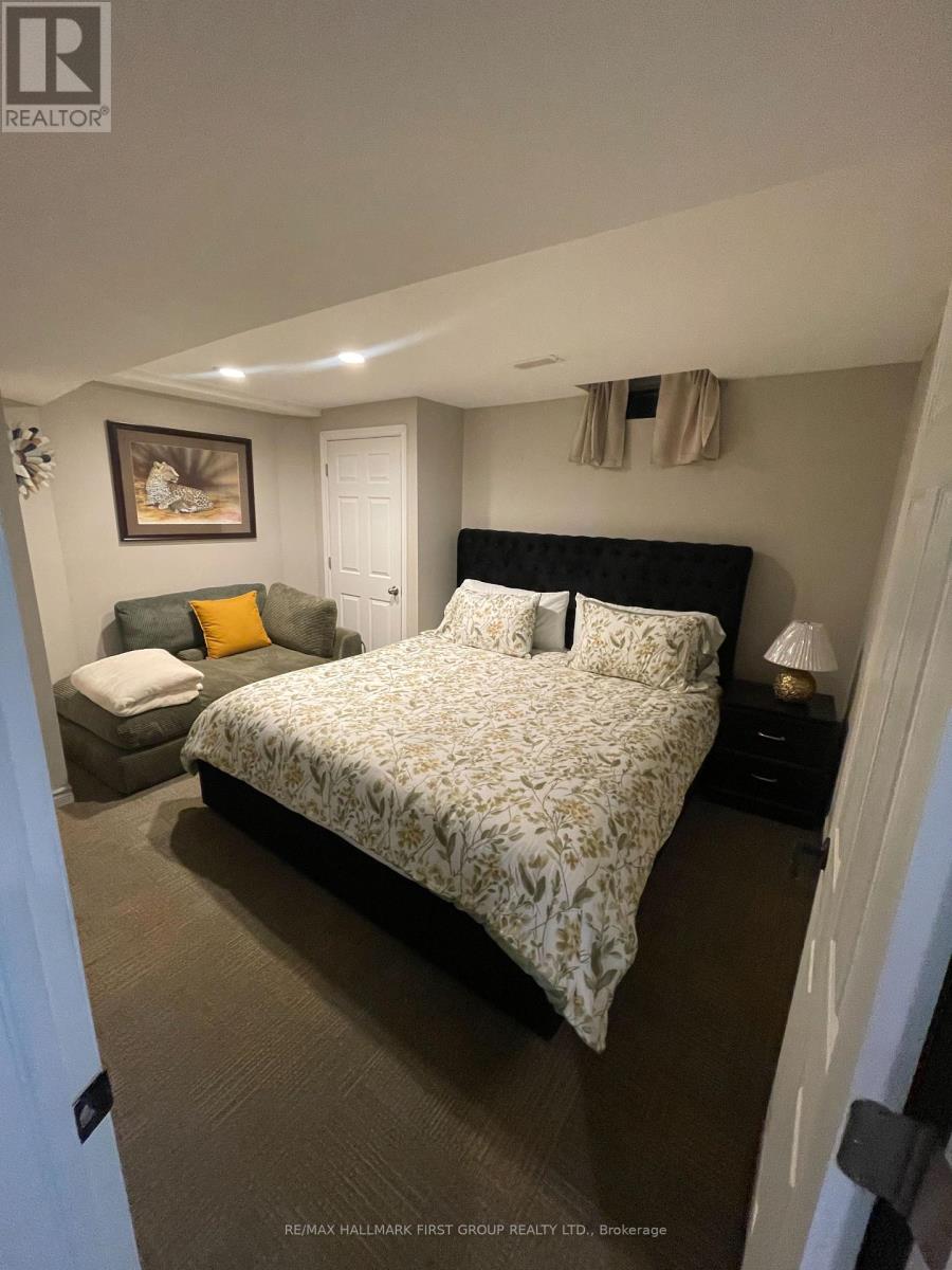 A bedroom with a large bed and a painting on the wall.