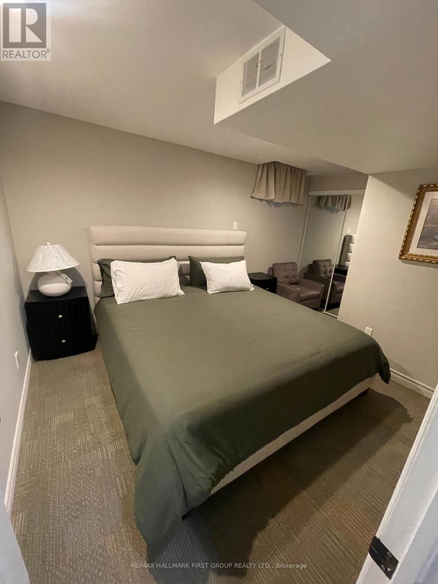A bedroom with a bed, nightstand, and lamp.