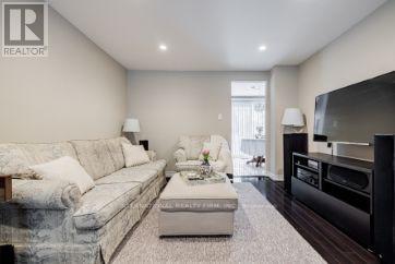 A living room with a grey couch, a coffee table, and a flat screen TV.
