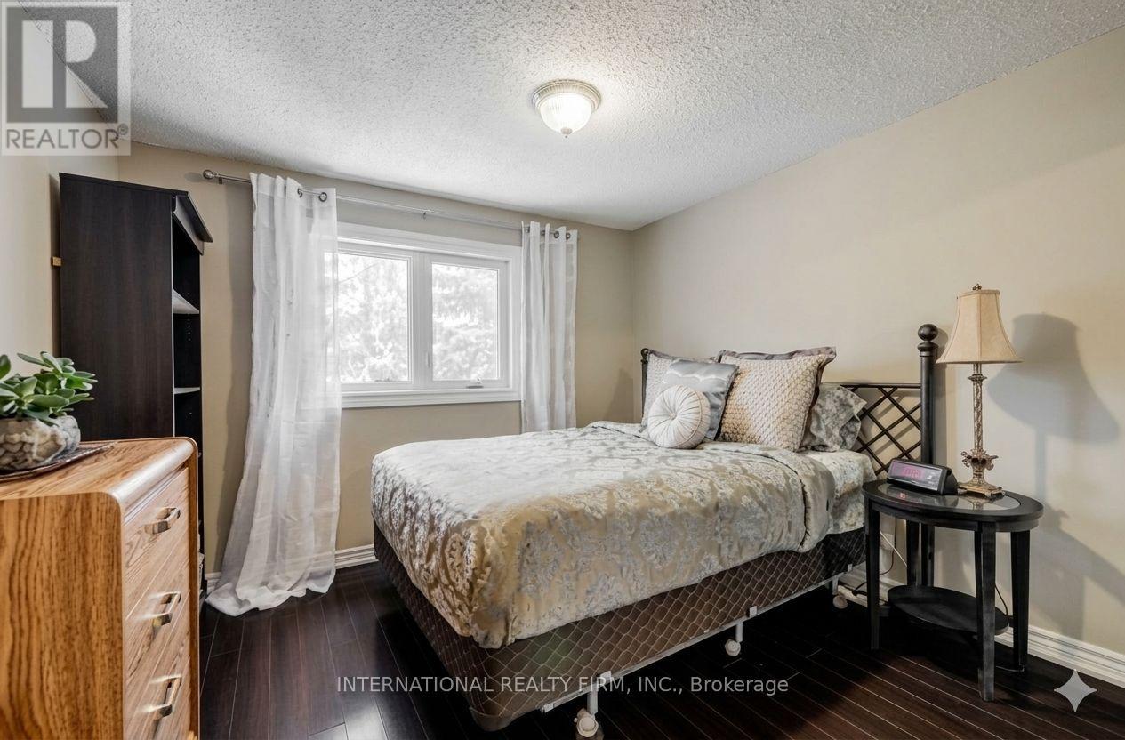 A bedroom with a bed, nightstand, and lamp.