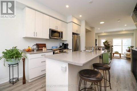 A kitchen with white cabinets and a large island with bar stools.