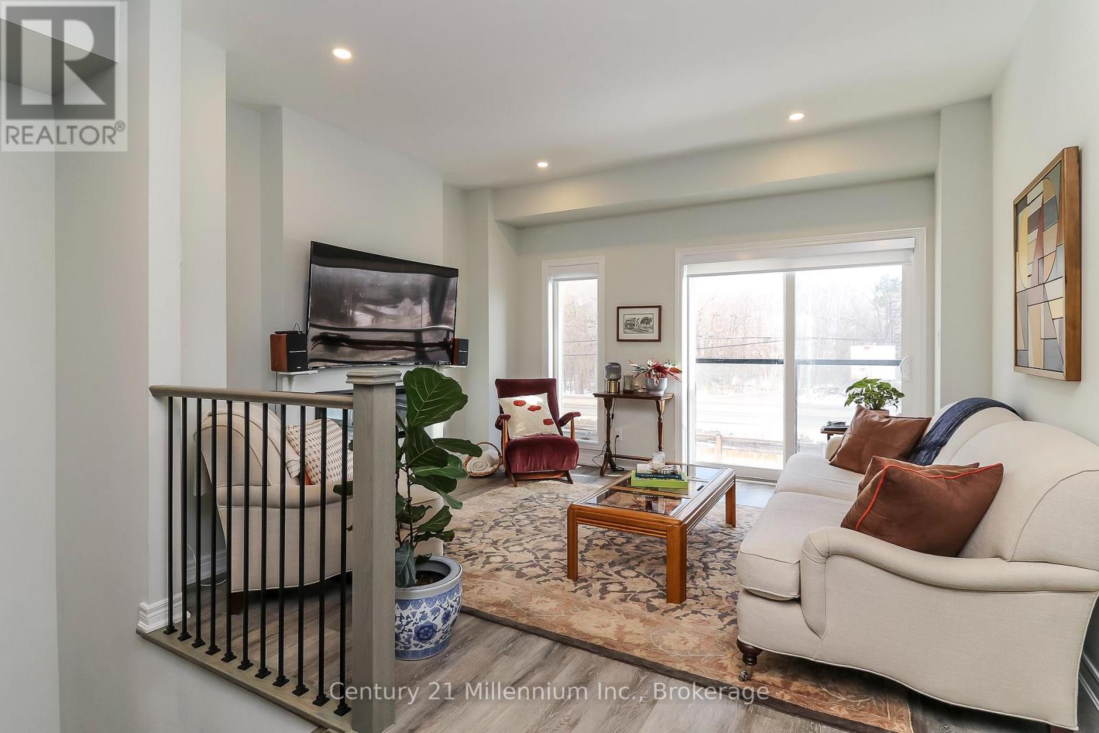 A living room with a white couch, a coffee table, and a television.