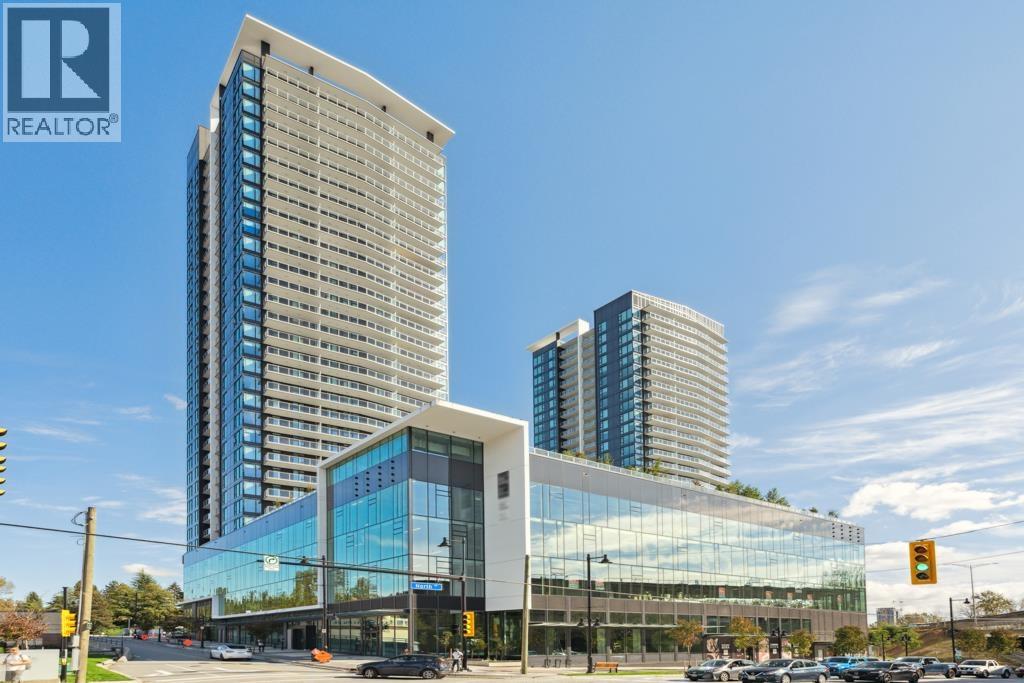 A modern glass building with a REALTOR® logo on the top left corner.