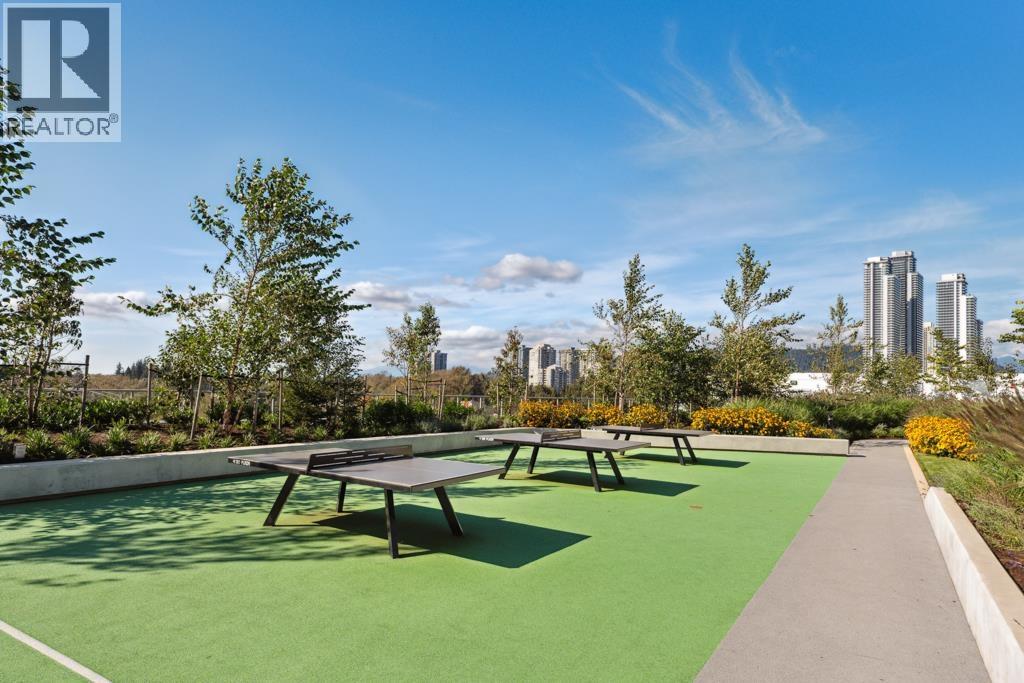 A playground with a green surface and picnic tables.