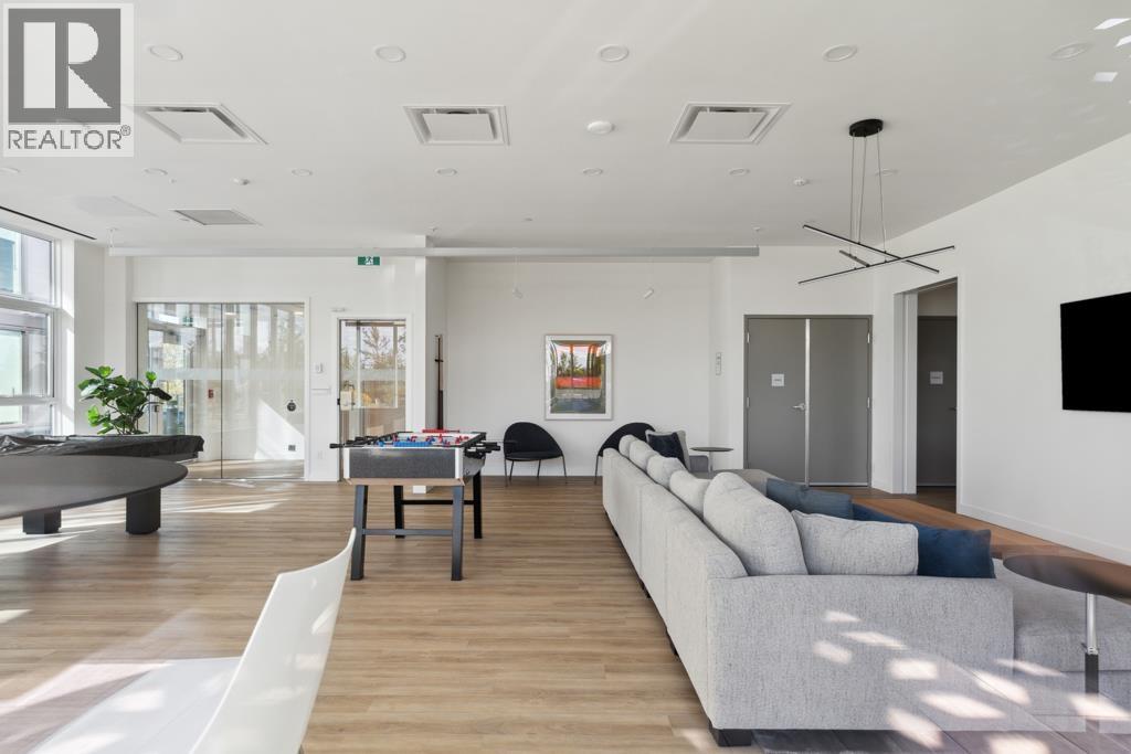 A modern living room with a pool table and a long couch.