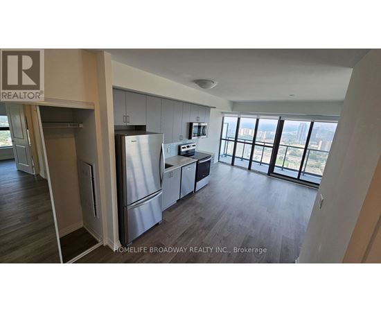 A kitchen with a refrigerator, cabinets, and a microwave.
