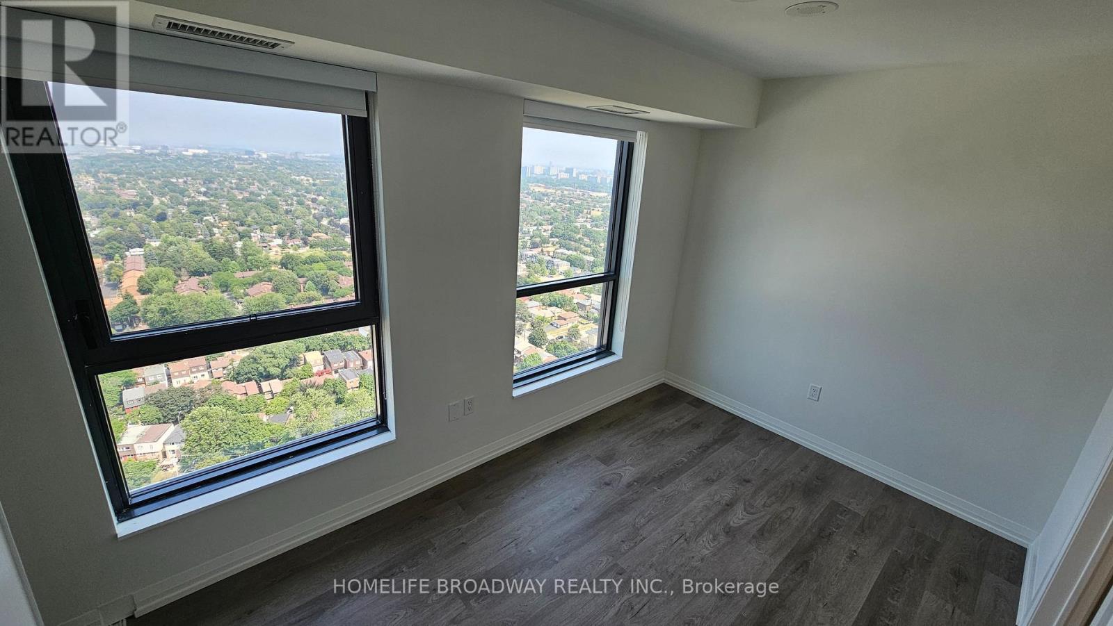 A room with a view of the city from a large window.