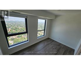 A room with a view of the city from a large window.