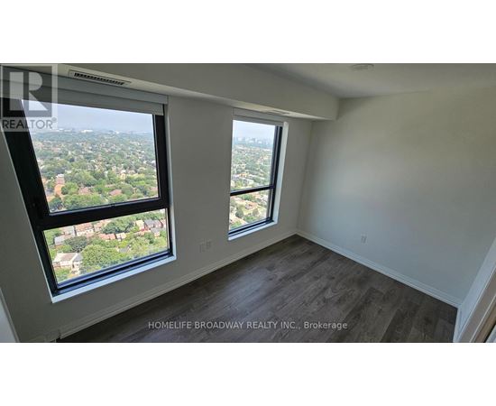 A room with a view of the city from a large window.