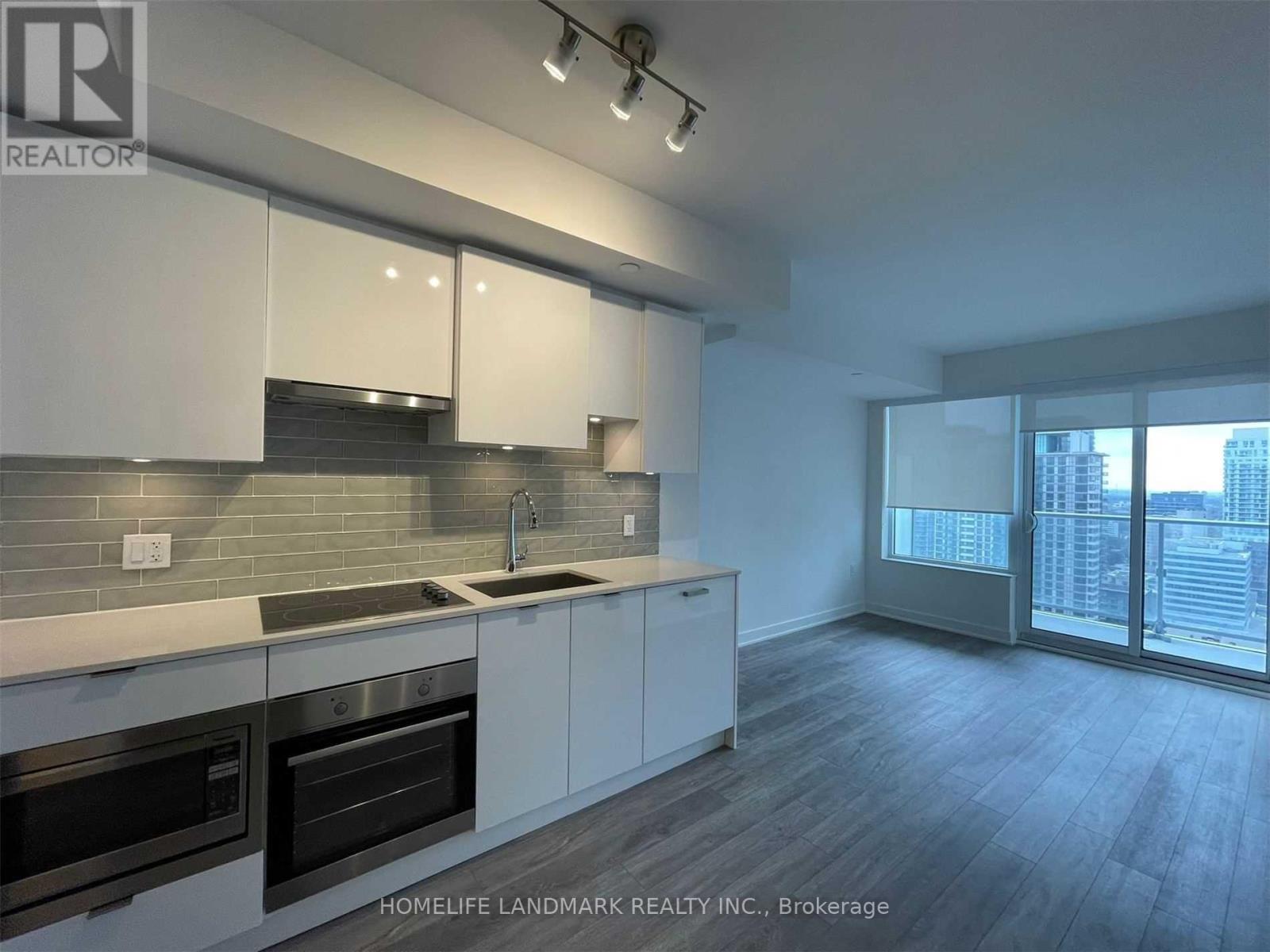 A modern kitchen with white cabinets and stainless steel appliances.
