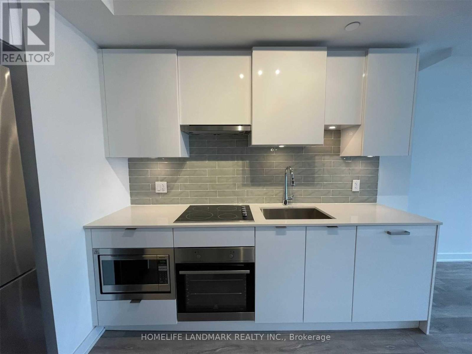 A kitchen with white cabinets and a black oven.