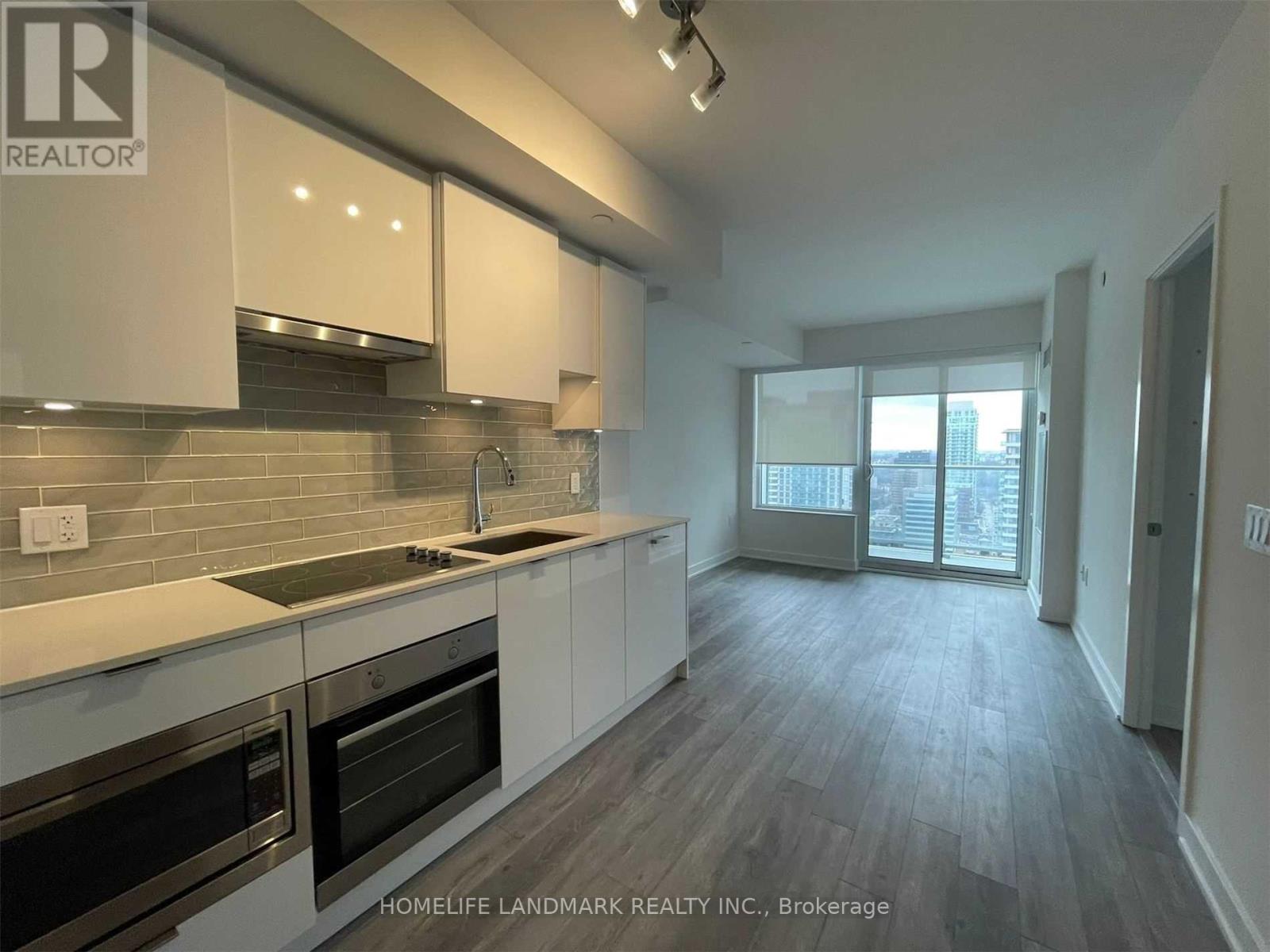 A modern kitchen with white cabinets and stainless steel appliances.