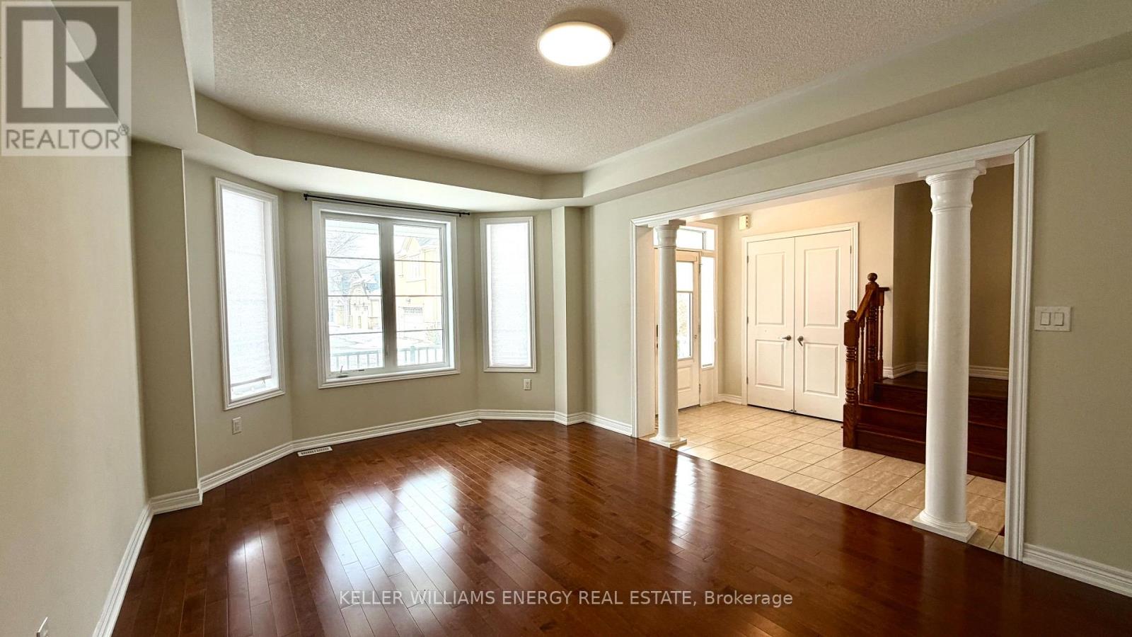 A spacious room with wooden floors and white walls.