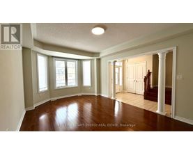 A spacious room with wooden floors and white walls.