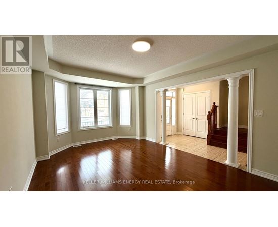 A spacious room with wooden floors and white walls.